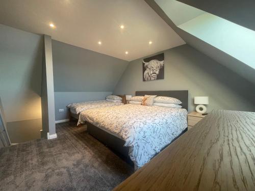 a bedroom with two beds in a attic at An Bothan in Mallaig