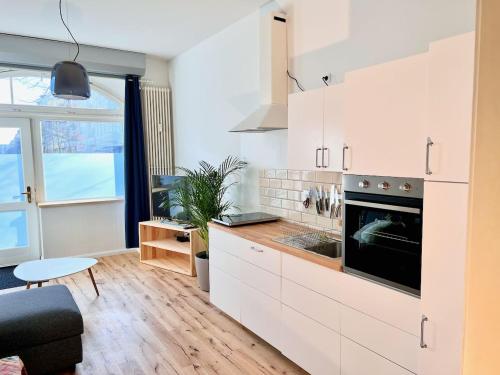 a kitchen with white cabinets and a stove at Central apartment in trendy Friedrichshain in Berlin