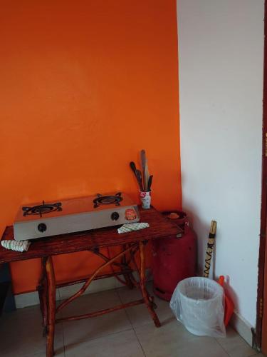 eine orangefarbene Wand mit einem Herd auf einem Holztisch in der Unterkunft STUX HOMES in Mombasa