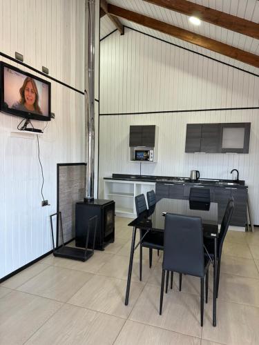 a room with a table and a tv on a wall at Complejo Turístico Los Laureles Arauco in Arauco