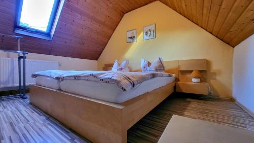 ein großes Bett in einem Zimmer mit Holzdecke in der Unterkunft Ferienhaus Reichel in Kurort Oberwiesenthal