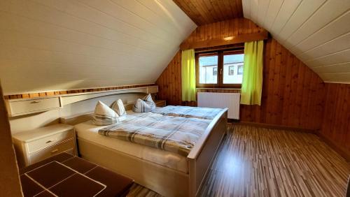 ein kleines Schlafzimmer mit einem Bett im Dachgeschoss in der Unterkunft Ferienhaus Reichel in Kurort Oberwiesenthal