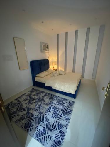 1 dormitorio pequeño con 1 cama y 1 silla azul en روحانه, en Salhabah