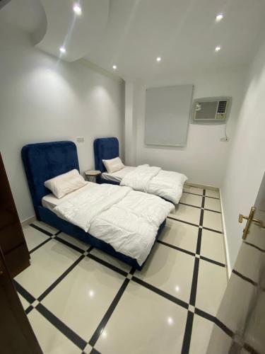 Habitación con 2 camas y 2 sillas azules en روحانه en Salhabah