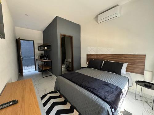 a bedroom with a bed and a table and a window at Vidrio Suites Col Americana in Guadalajara