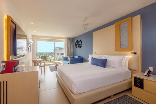 a bedroom with a large bed with a blue wall at Royalton Splash Riviera Cancun, An Autograph Collection All-Inclusive Resort in Cancún