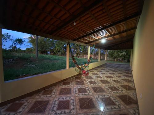 um quarto com um alpendre com um baloiço em Jardim Canastra em São Roque de Minas