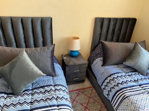 two beds sitting next to each other in a room at Superbe appartement proche de toutes les commodité in Rabat