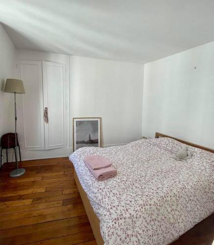 ein Schlafzimmer mit einem Bett und einem rosa Handtuch darauf in der Unterkunft Appartement proche Arc Triomphe / Champs Elysées in Paris