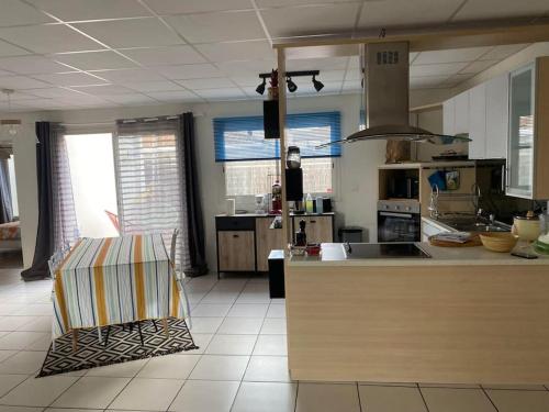 - une cuisine avec un comptoir et une chaise dans une pièce dans l'établissement Les oiseaux Mimizan Plage, à Mimizan