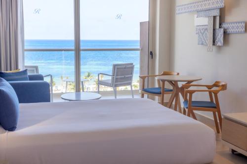 a bedroom with a bed and a view of the ocean at Royalton Splash Riviera Cancun, An Autograph Collection All-Inclusive Resort in Cancún
