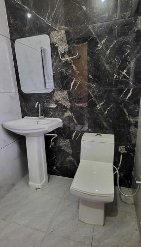 a bathroom with a white toilet and a sink at Hotel Panipat Town House in Pānīpat