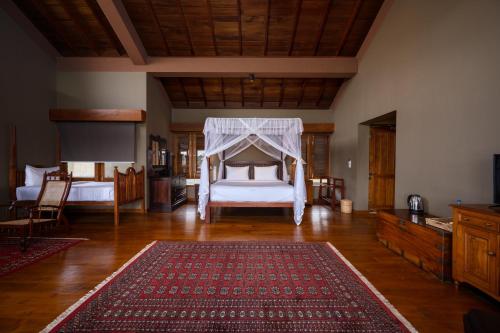 Atulya Villas Nuwara Eliya في نوارا إليا: غرفة معيشة مع سرير وسجادة