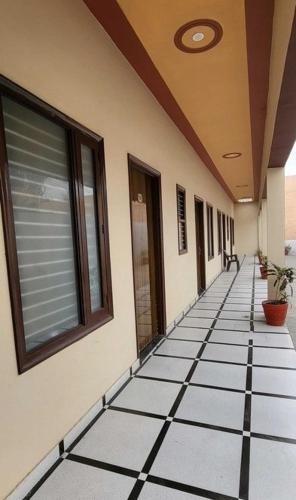 a hallway of a building with a tiled floor at Hotel Panipat Town House in Pānīpat