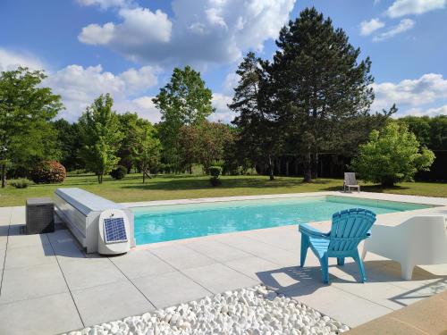 une chaise bleue assise à côté d'une piscine dans l'établissement Ecoute s,il vient, à Gourdon