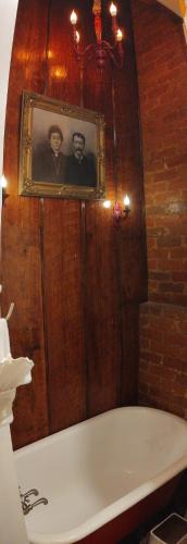 a bath tub in a bathroom with a picture on the wall at The Blue60 Marigny Inn in New Orleans