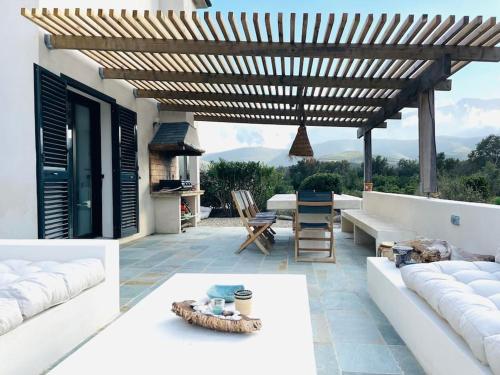 Elle comprend une terrasse dotée d'un mobilier blanc et d'une pergola en bois. dans l'établissement VILLA CARCO VECCHIO II, à Pietracorbara