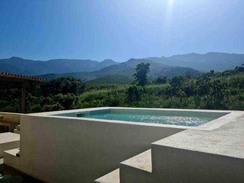 une piscine avec vue sur les montagnes dans l'établissement VILLA CARCO VECCHIO II, à Pietracorbara