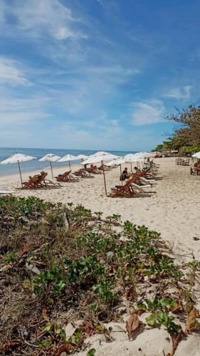 a group of people sitting on a beach with umbrellas at Aquarela Praia Hotel in Arraial d'Ajuda
