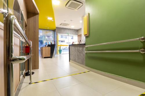 a hallway with a green wall and a white tile floor at Tarobá Express in Foz do Iguaçu