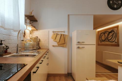 a kitchen with a white refrigerator and a sink at Thalpo home in Ioannina