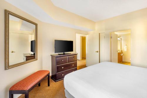 a bedroom with a bed and a mirror and a television at Hilton Vacation Club Polo Towers Las Vegas in Las Vegas
