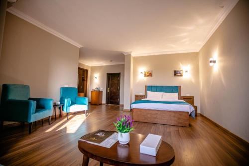 Habitación de hotel con cama, mesa y sillas en Nile cruise, en Jazīrat al ‘Awwāmīyah