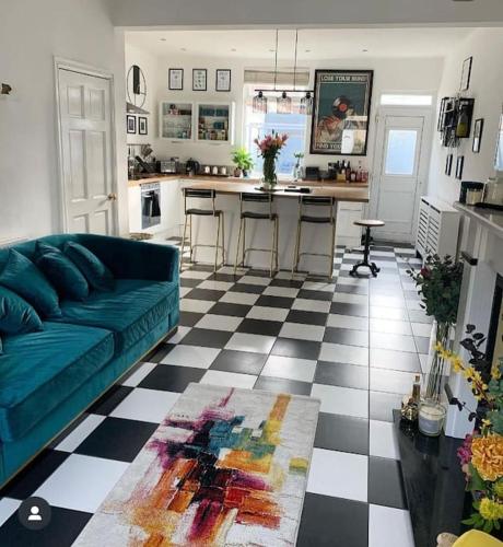 ein Wohnzimmer mit einem blauen Sofa und einer Küche in der Unterkunft The Tiled Terrace in Liverpool
