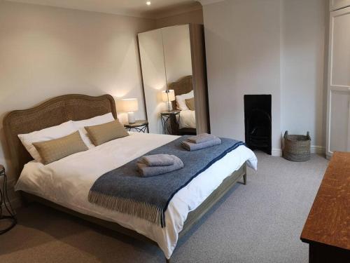 a bedroom with a large bed with two towels on it at Owl's Hoot in Snettisham