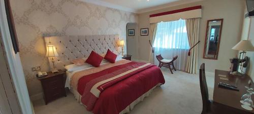 a bedroom with a large bed with a red blanket at Brook Manor Lodge in Tralee