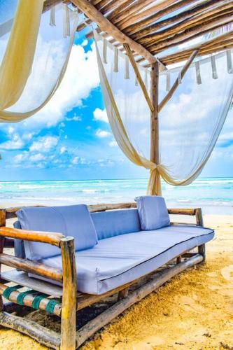 a bed on a beach with the ocean in the background at Exclusive Villa * private Beach and Housekeeping in Punta Cana