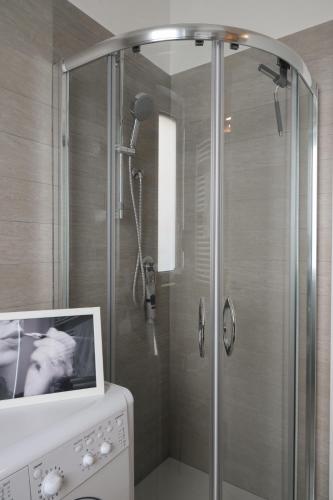 a bathroom with a shower with a picture on the counter at Dimora Pacelli in Castellana Grotte