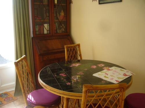 Appartement Angelo في سانت-ماري-دو-مونت: طاولة غرفة طعام مع كراسي وخزانة زجاجية