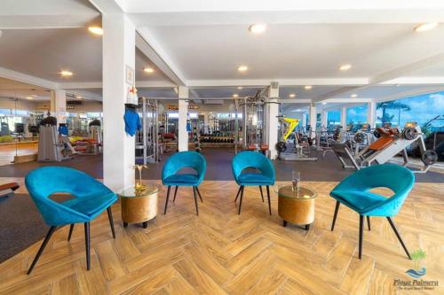 un gimnasio con sillas azules y equipo de ejercicios en Exclusive Villa * private Beach and Housekeeping, en Punta Cana