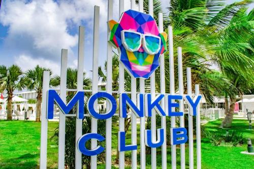 a sign for a monkey club with a colorful mask at Exclusive Villa * private Beach and Housekeeping in Punta Cana
