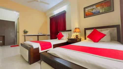 two beds in a hotel room with red pillows at Hotel Golden Inn Dhaka in Dhaka