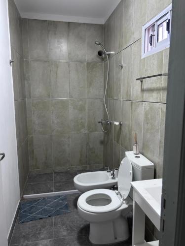 uma casa de banho com um WC, um chuveiro e um lavatório. em Apart Luro IV em Santa Rosa