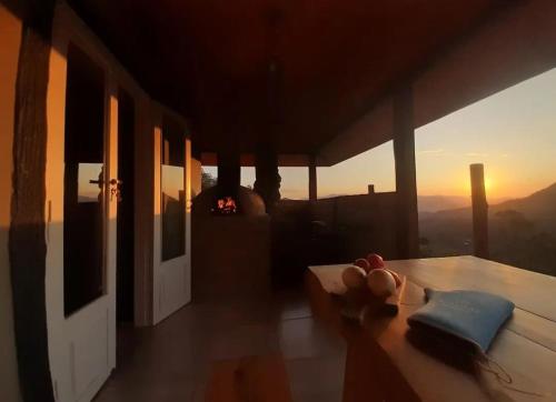a room with a table with a view of the sunset at Cabana do Camelo in São Bento do Sapucaí