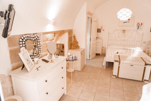 una camera con cassettiera bianca e una camera da letto di Karen House B&B a Polignano a Mare