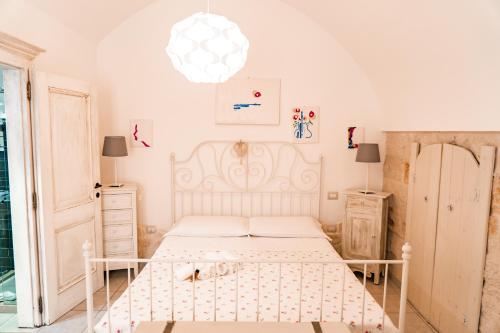 a bedroom with a white bed and a chandelier at Karen House B&B in Polignano a Mare