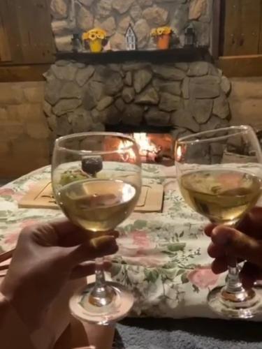 two people holding glasses of white wine at a table at Cabana do Camelo in São Bento do Sapucaí