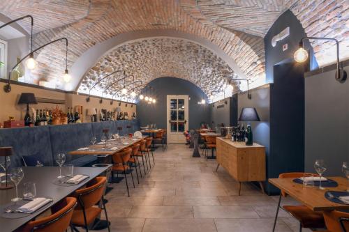 un restaurante con mesas y sillas y techo de ladrillo en HILL COLLE - camere & bistrot, en Villa Pedergnano