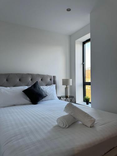 um quarto com uma cama branca e uma almofada em Spacious 2BR with balcony in Brentwood em Brentwood