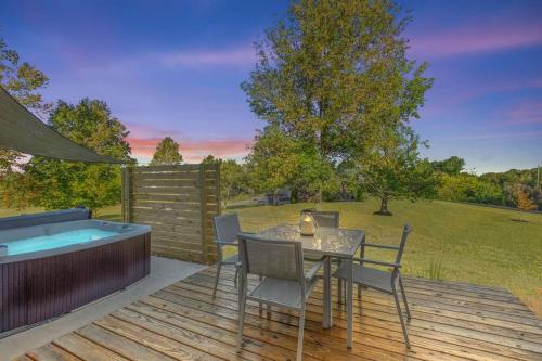 a deck with a table and chairs and a hot tub at The Luxe/Hot Tub/ Putt Putt/10 Mins Shaker Village in Harrodsburg