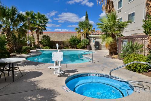 uma piscina com uma mesa e uma cadeira ao lado de um edifício em Staybridge Suites Las Cruces, an IHG Hotel em Las Cruces