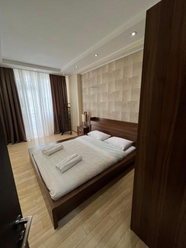 ein Schlafzimmer mit einem großen Bett mit weißer Bettwäsche und Kissen in der Unterkunft Lost in Tbilisi in Tbilisi City