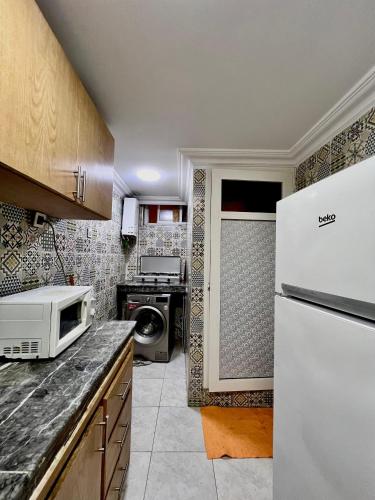 uma cozinha com um frigorífico branco e um micro-ondas em Dar al anbar em Rabat