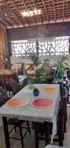 a table with plates on it with plants on it at Pousada em Fazenda Nova Dona Rosy in Fazenda Nova