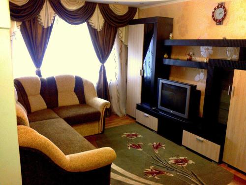 a living room with a couch and a television at Petropavlovskaya in Sumy