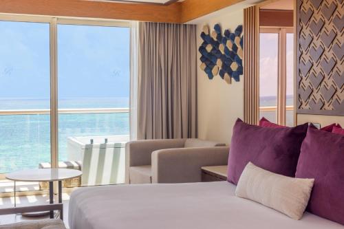 a hotel room with a bed and a view of the ocean at Royalton Splash Riviera Cancun, An Autograph Collection All-Inclusive Resort in Cancún